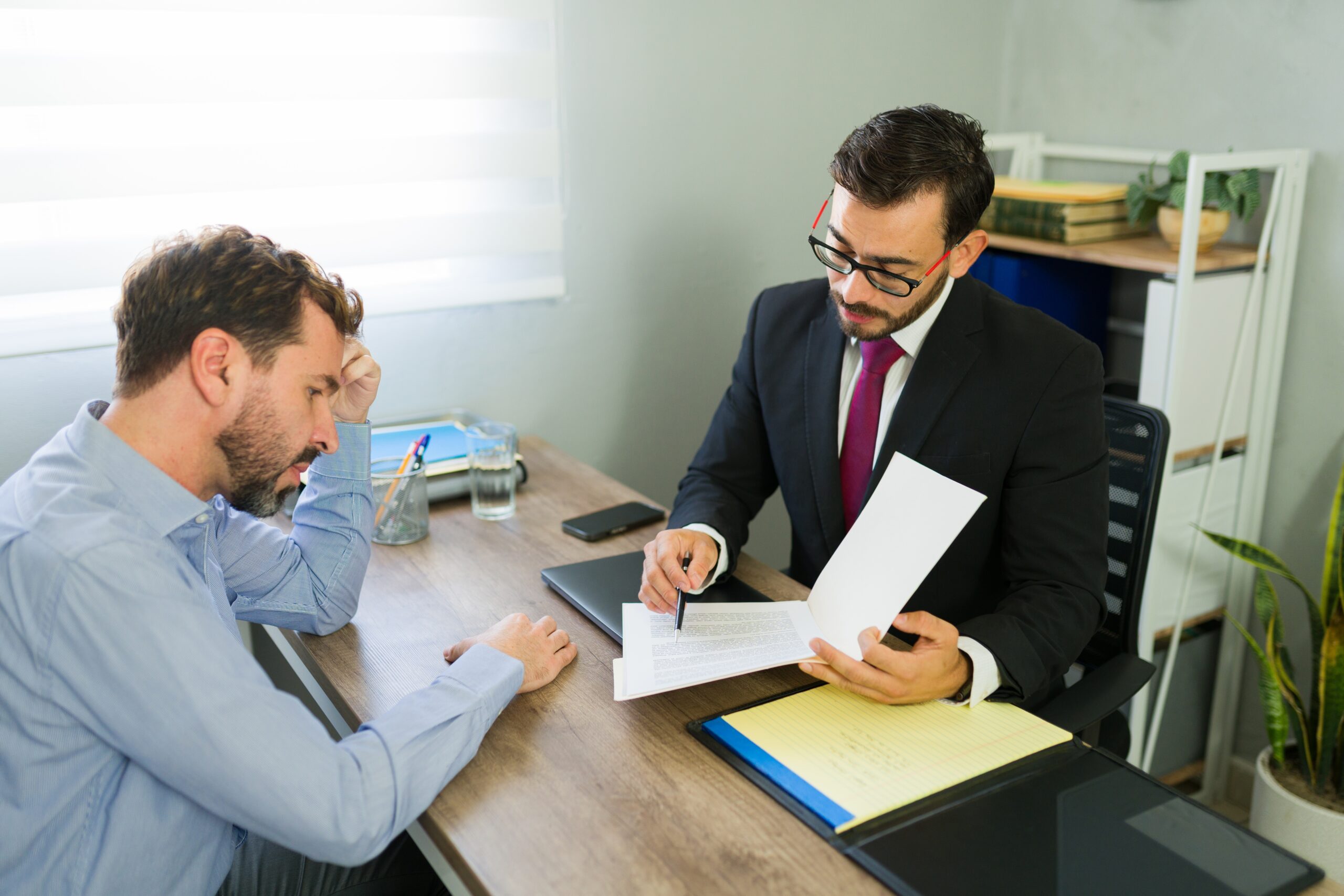 MaleClientReceivingLegalAdviceFromALawyerInA - Levin Ginsburg Attorney working with an employer to update employee handbook